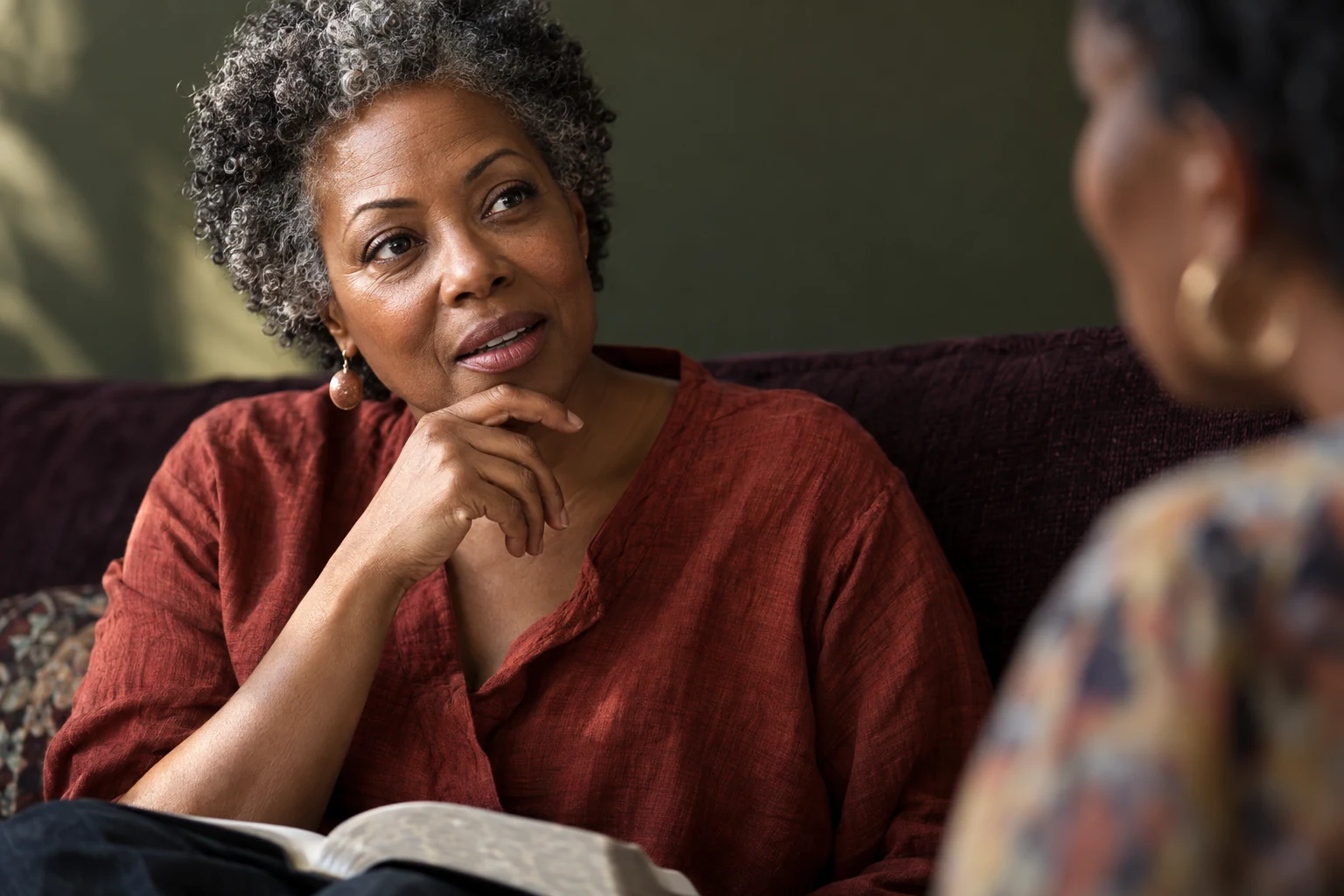 A woman with silver-flecked curls pauses thoughtfully before answering a Bible-study question.